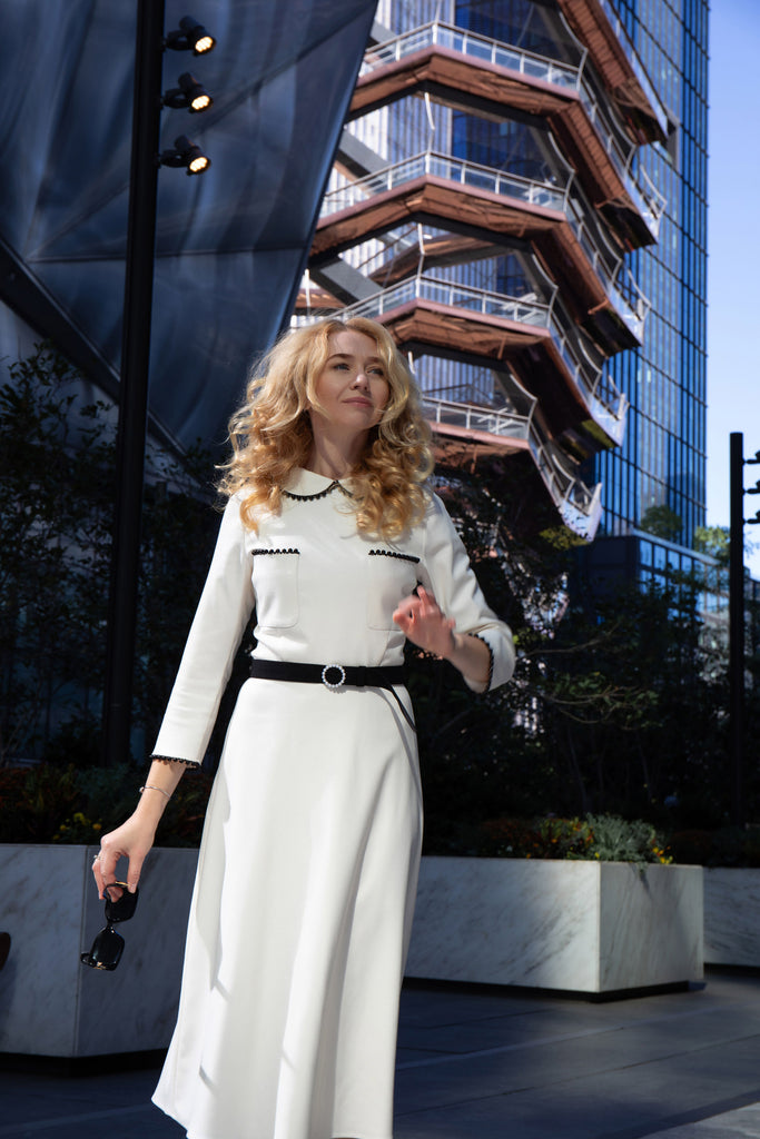 Close-up of black-trimmed collar and cuffs on white dress by Anastasiia Ivanova