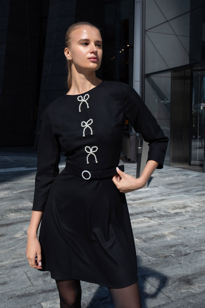 Detail shot of pearl buckle belt on black dress by Anastasiia Ivanova.