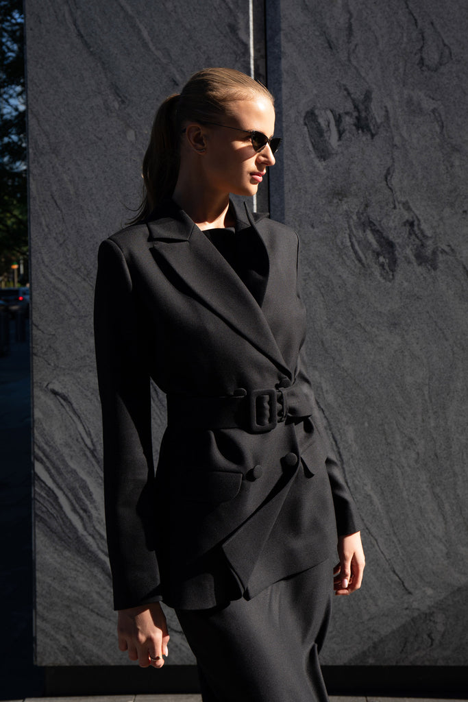 Side view of fitted black blazer with belt and flap pockets by Anastasiia Ivanova