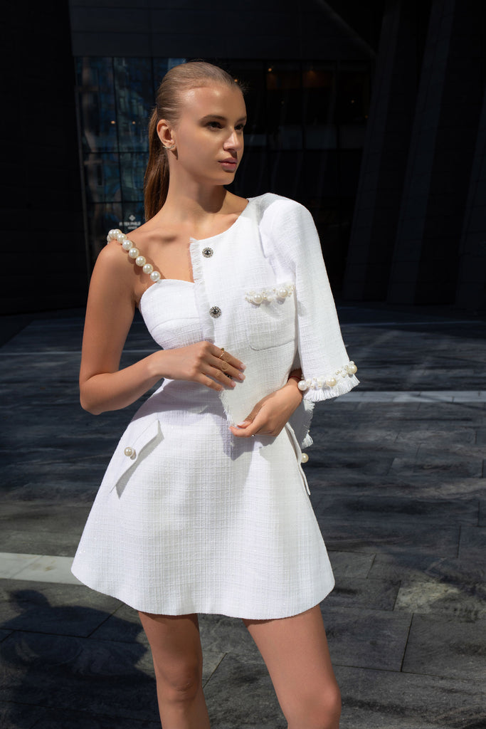 White tweed jacket with pearl embroidery draped over the shoulder of matching sundress by Anastasiia Ivanova, chic limited-edition look