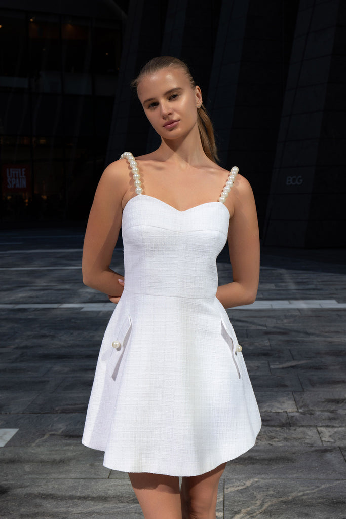 Front view of white tweed sundress with pearl straps by designer Anastasiia Ivanova, elegant mini dress photographed outdoors in New York