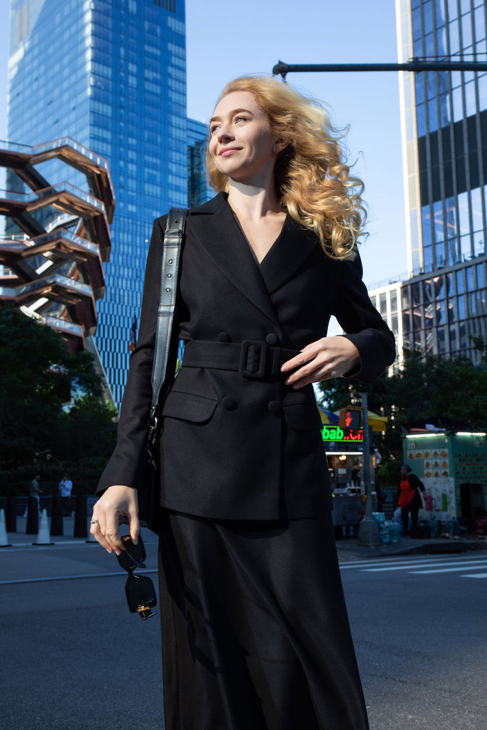 Front view of black tailored blazer with belt by Anastasiia Ivanova, styled with black midi skirt in New York