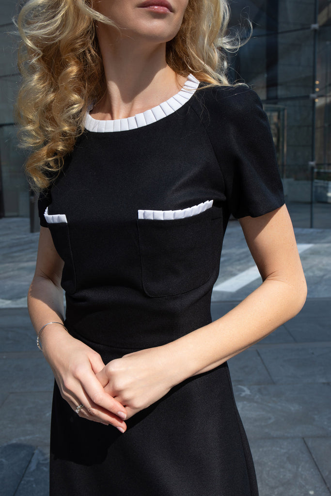 Close-up of decorative patch pockets and handcrafted pleats on black dress by Anastasiia Ivanova.