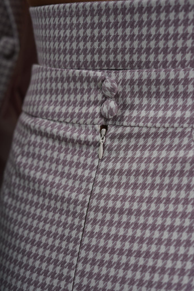 Close-up of waistband and decorative buttons of wool houndstooth skirt