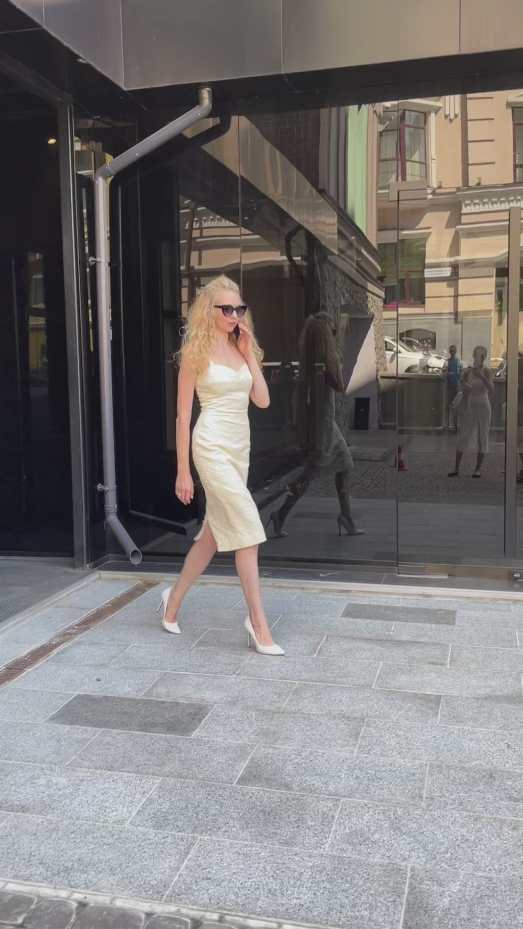 A dynamic video showcasing the ivory jacquard midi dress by Anastasiia Ivanova. The model walks confidently through city streets, highlighting the fitted sweetheart neckline, delicate straps, and premium textured fabric. Styled with a draped blazer and sunglasses, this is the ultimate metropolitan outfit for a chic civil wedding, city hall ceremony, or rehearsal dinner