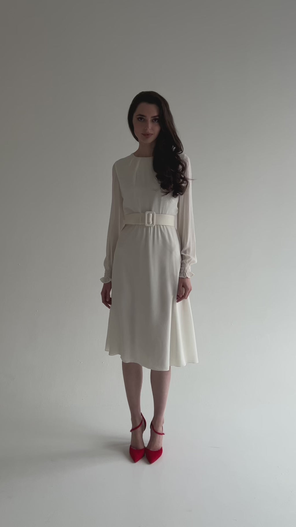 A detailed video demonstration of the white and red chiffon midi dress with long sleeves and a belt. The model turns, poses, and makes creative movements, emphasizing the lightness and movement of the airy fabric. Elegant design by Anastasiia Ivanova